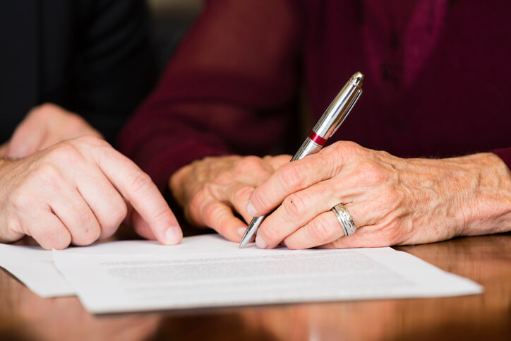 Older woman signing legal document