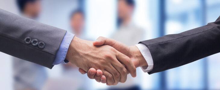 close up two businessman hand shake together for agreement successful on blur group of businesspeople talking in meeting room , achievement concept