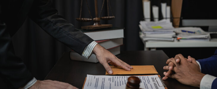 Lawyer holds a pen and provides consulting services in business disputes with a scale and hammer. In the event that the customer is defrauded Close-up pictures